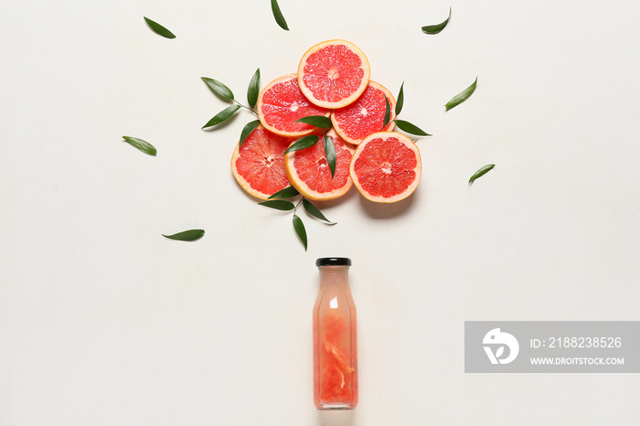 Creative composition with bottle of juice and ripe grapefruits on white background