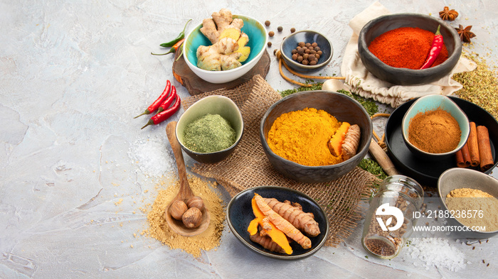 Assortment of Indian spices on gray background.