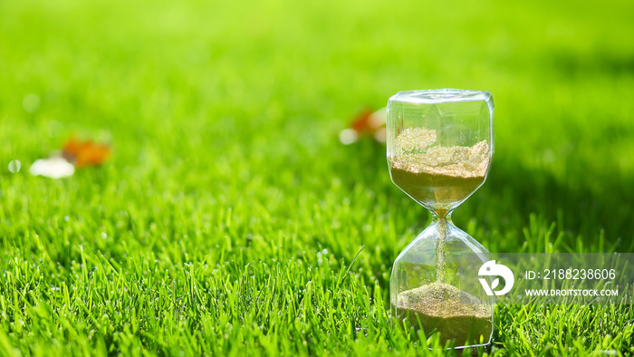 Hourglass on green grass outdoors