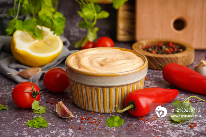 Bowl of tasty chipotle sauce on grunge background