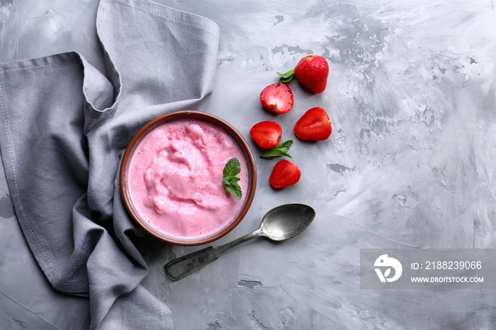 Bowl with tasty strawberry yogurt ice cream on table