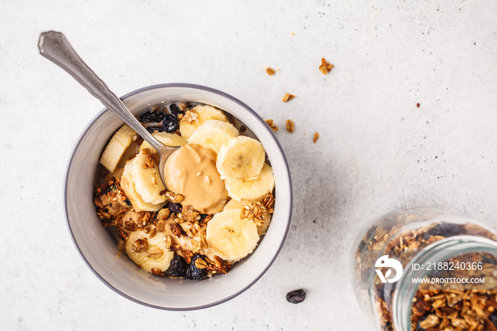 Baked granola with raisins, banana and peanut butter, top voew, copy space.