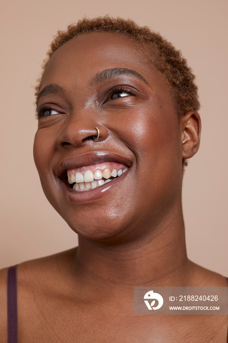 Studio portrait of smiling woman with nose ring