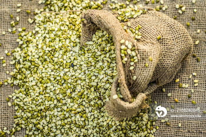 Split Green gram,Moong dal,Vigna radiata coming out from a gunny bag.;