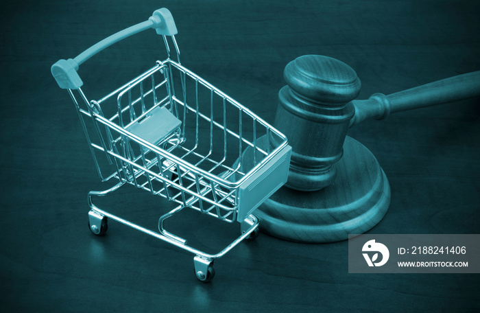 Wooden judge gavel and shopping cart close up