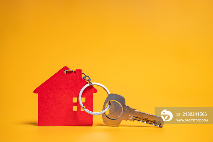 concept mockup of wooden house keyring with key, representing house loan, real estate, expenses financial data and business of tax money payment on owning property, on isolated yellow background