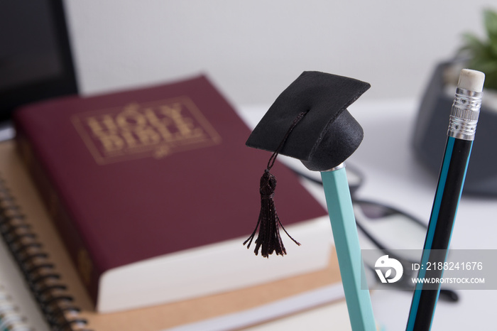 Graduate cap on the background of the holy bible. Spiritual education concept