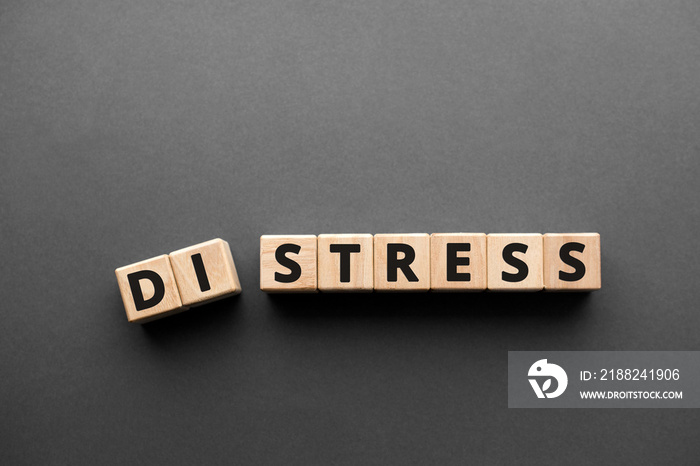 Distress Stress  - words from wooden blocks with letters, distress to stress concept, top view gray background