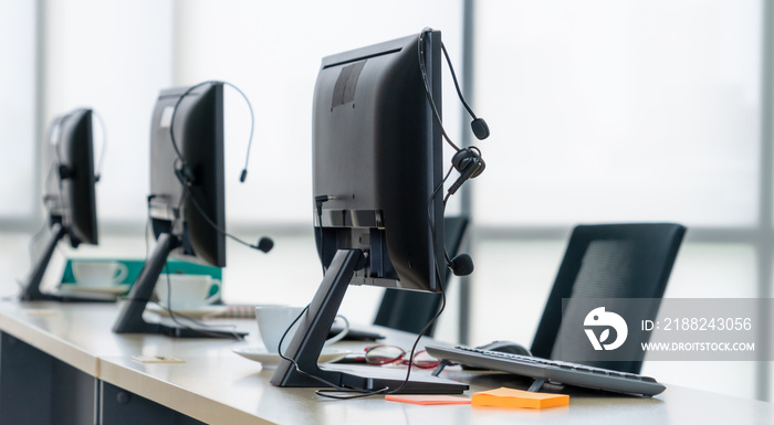 Call center computers and headsets all in office. Telemarketing, customer support agent provide service on telephone video conference call.