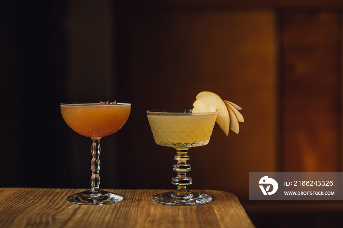 autumn fall cocktails in fancy vintage glassware against warm wood background