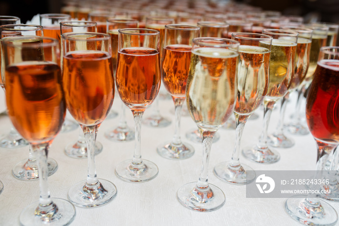 Many wine glasses with a cocktail on the white table.