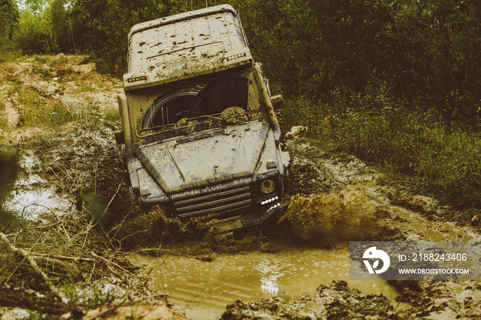 Mud and water splash in off the road racing. Tracks on a muddy field. Off-road vehicle goes on mountain way. Expedition offroader. Jeep crashed into a puddle and picked up a spray of dirt.