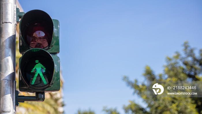 Green traffic lights for pedestrians, blue sky background