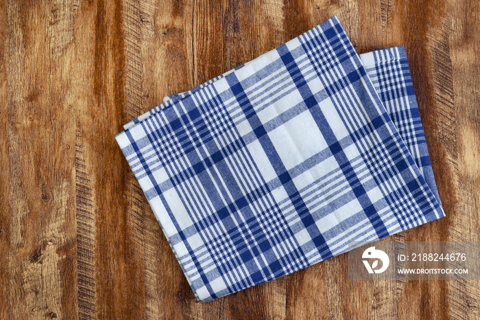 Striped kitchen towel isolated on wood background, top view