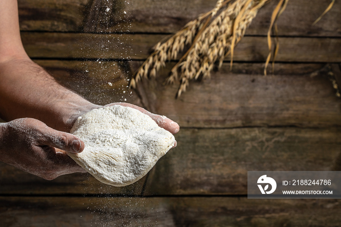 yeast dough for bread or pizza on a floured surface, with flour splash. Cooking bread. Kneading the Dough