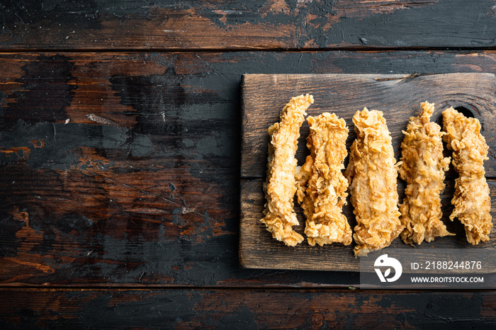 Crispy fried chicken broast on old dark wooden table, top view, with copy space