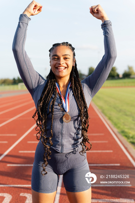 Portrait of female athlete celebrating with medal