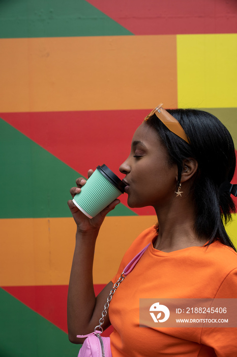 Young woman drinking take-out coffee outdoors