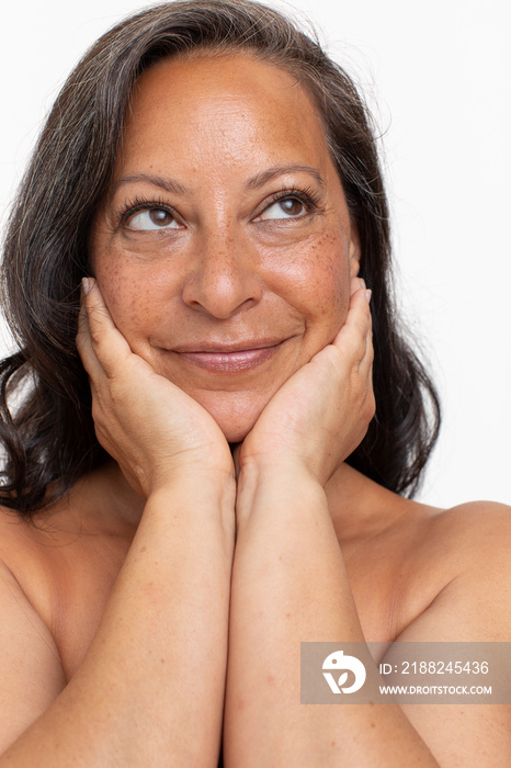 Studio portrait of smiling shirtless woman looking up