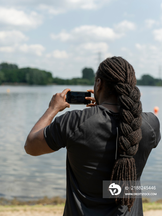 Man photographing lake with smart phone