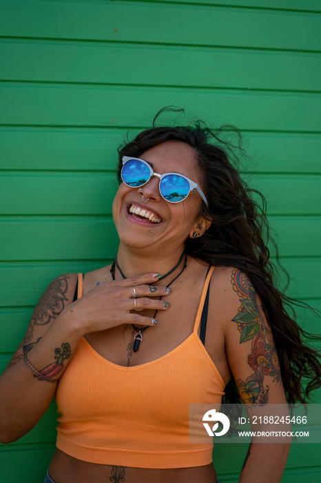 Smiling mid adult woman with tattoos and sunglasses