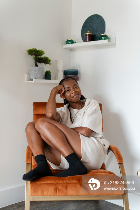 Portrait of smiling woman sitting in armchair at home