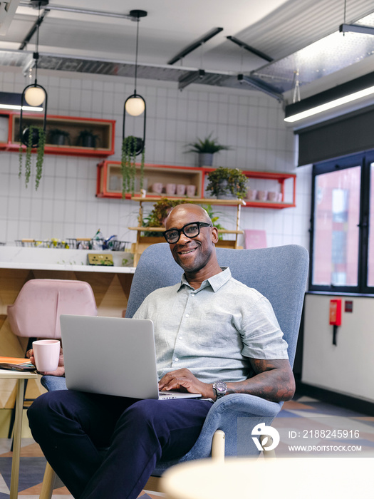 Man using laptop in office cafeteria