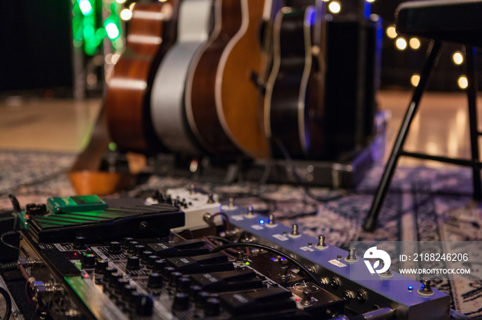 Pedalboard and multiple guitar stand on a stage - Low angle picture taken at a storytelling and folk music festival in Quebec, Canada