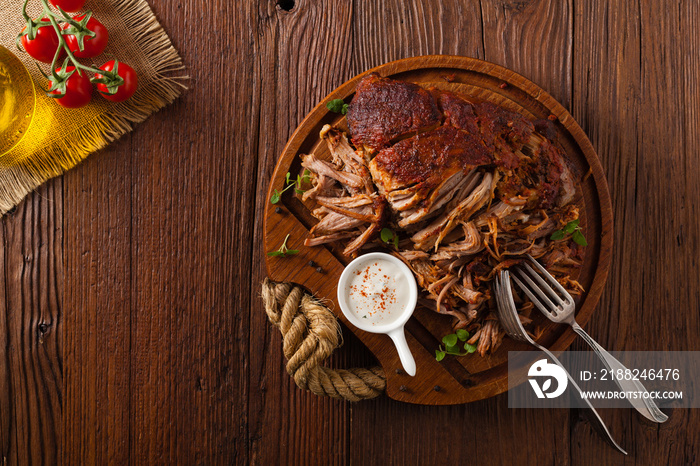 Pulled pork on a wooden board. Top view.