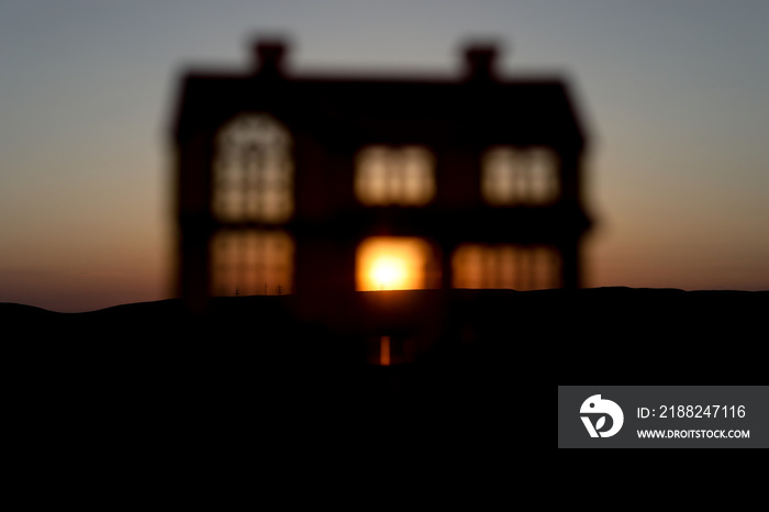 decorative small metallic house on the sunset background. Selective focus