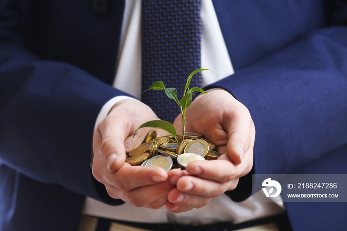 Handful of coins with growing sprout, closeup view