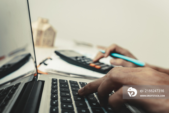 Young business man doing calculator finance cost in home office.