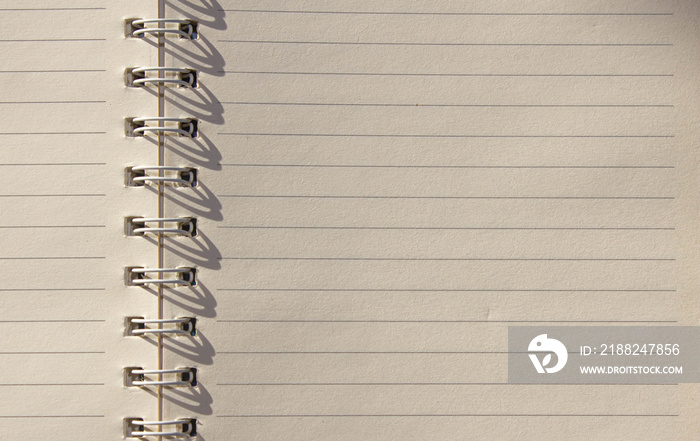 Notebook on a spiral spring with textured papper of white color as the background