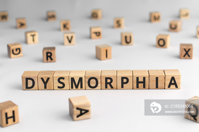 Dysmorphia - word from wooden blocks with letters, body dysmorphic disorder concept, random letters around, white  background