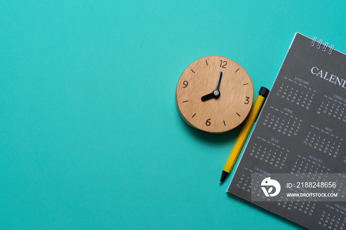 close up of calendar and alarm clock on the green table background, planning for business meeting or travel planning concept