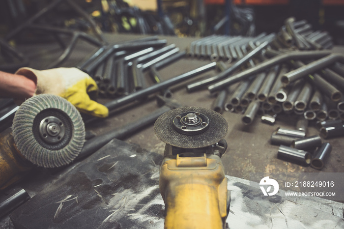 Steel pipe and grinders on a work bench.