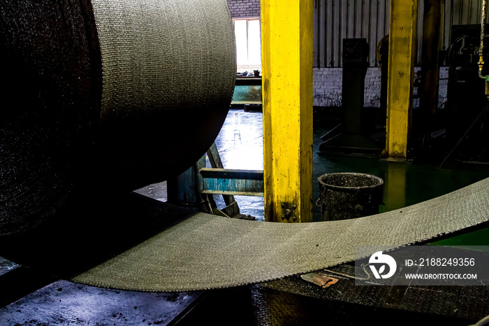 Close up of a roll of rubber on a machine in a conveyor belt factory