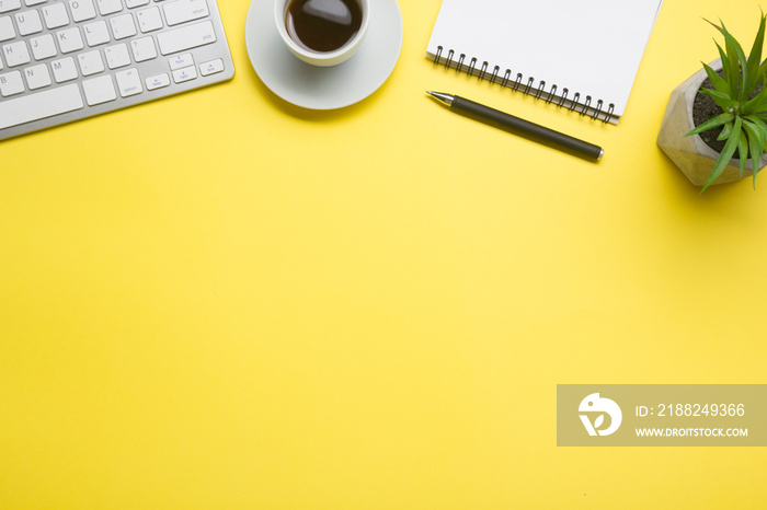 Yellow desk office with laptop, smartphone and other work supplies with cup of coffee. Top view with copy space for input the text. Designer workspace on desk table essential elements on flat lay