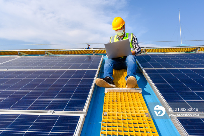 Engineers use a laptop computer to examine the solar panels at a power plant installed with solar panels using solar energy.