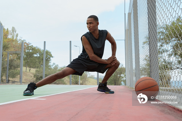 African man stretching before training on court