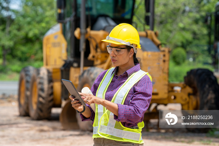 Portrait of confident female architect wearing hard hat and reflective vest at construction site.