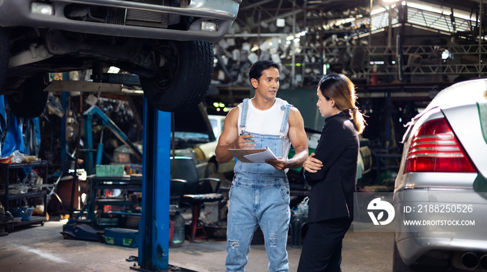 Asian young woman customer talking with owner and mechanic worker at car repair service and auto store shop.