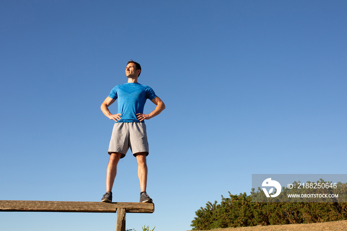 man standing on bench looking confident