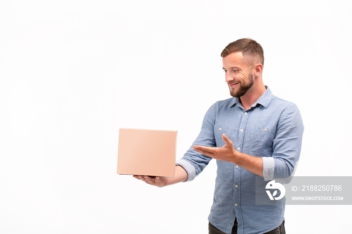 Casual young man holding a box isolated on a white background