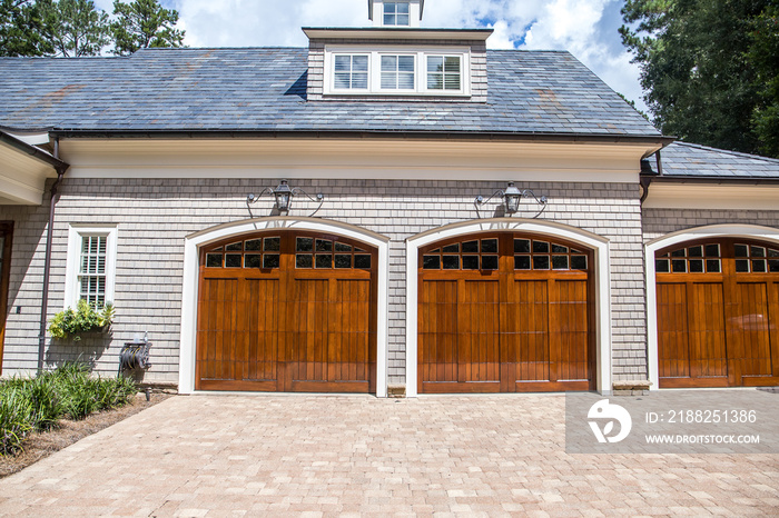 Stained wood custom double garage doors for large southern home with curb appeal