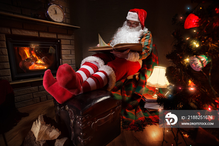 Santa Claus sitting at his room at home near Christmas tree and  resting by his fireplace