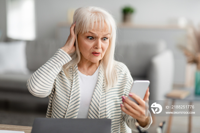 Shocked senior woman using her mobile phone