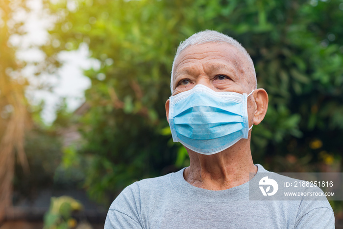 Portrait of elderly man with short white hair, wearing face mask for health because have air pollution PM 2.5. Mask for protect virus, coronavirus, bacteria, pollen grains. Health care concept