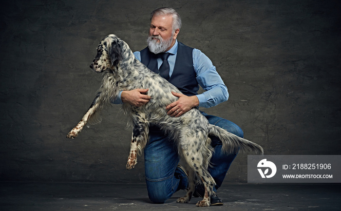 Old man and his dog irish setter breed against dark background