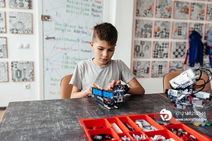 Child plays with a robotic toy assembled from the designer